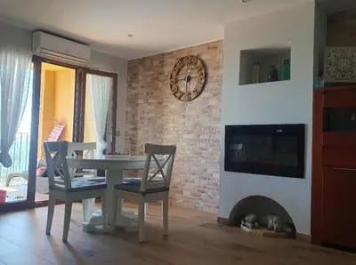 a living room with a table and chairs and a fireplace at Apartamento primerísima línea in Port Saplaya