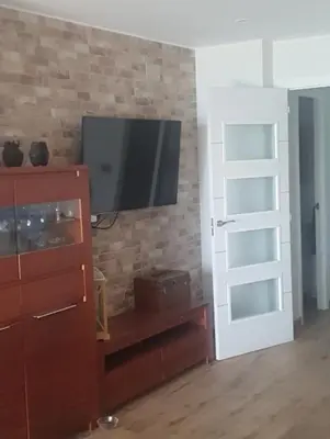 a living room with a television on a brick wall at Apartamento primerísima línea in Port Saplaya
