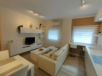 a living room with a white couch and a tv at Non Stress Turia in Valencia