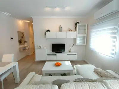 a white living room with a couch and a table at Non Stress Turia in Valencia