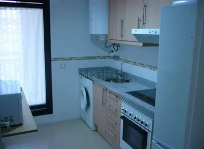 a white kitchen with a sink and a dishwasher at Piso acogedor con vistas al mar in La Torre