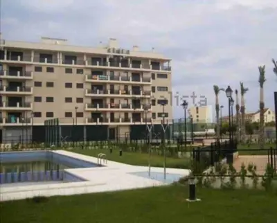 a large building with a pool in front of it at Piso acogedor con vistas al mar in La Torre