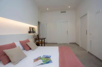 a bedroom with a large white bed with pink pillows at SingularStays Picaña in Picanya