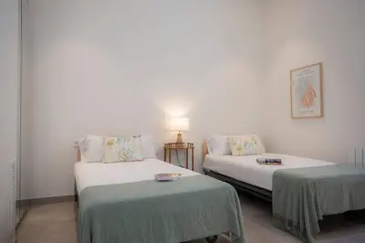 a room with two beds and a table and a lamp at SingularStays Picaña in Picanya