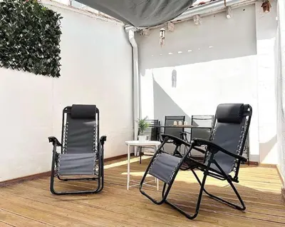 three black chairs and a table on a patio at Apartamento con Terraza cerca de la Estación del Nord in Valencia
