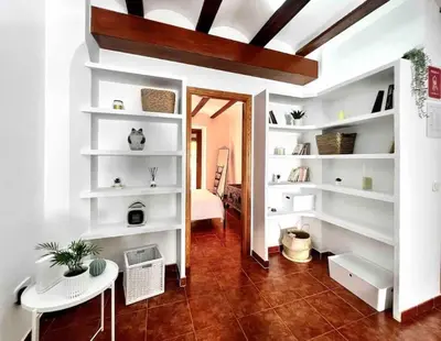 a living room with white shelves and a table at Apartamento con Terraza cerca de la Estación del Nord in Valencia