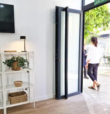a woman walking through an open door into a store at Apartamento nuevo cerca de la playa y céntrico in Valencia
