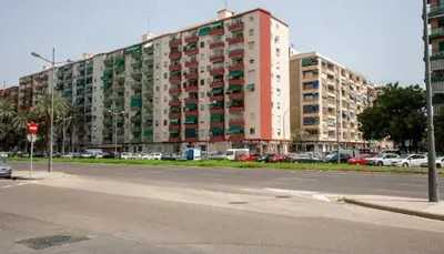 a large building with cars parked in a parking lot at Apartamento nuevo cerca de la playa y céntrico in Valencia