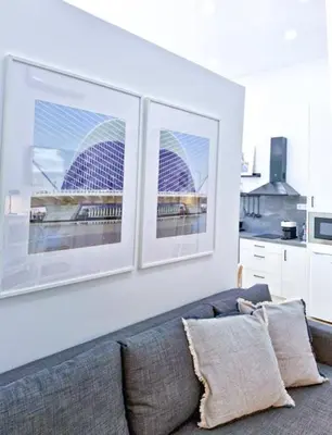 a living room with a couch and two pictures on the wall at Apartamento nuevo cerca de la playa y céntrico in Valencia