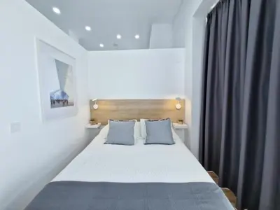 a bedroom with a bed with two blue pillows at Apartamento nuevo cerca de la playa y céntrico in Valencia