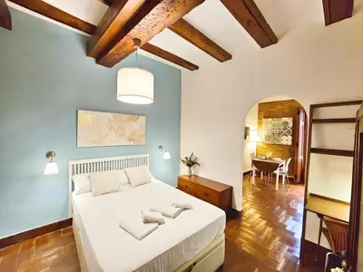 a bedroom with a white bed and a table at Bello apartamento cerca de la Plaza Redonda in Valencia