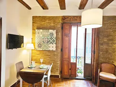 a dining room with a table and chairs and a wall at Bello apartamento cerca de la Plaza Redonda in Valencia