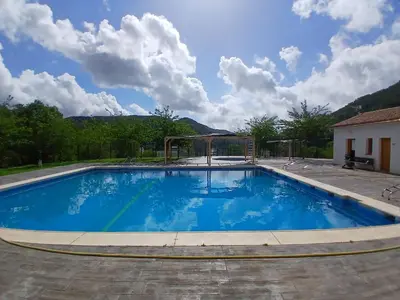 a large blue swimming pool with a gazebo at L'Amagatall in Ahín