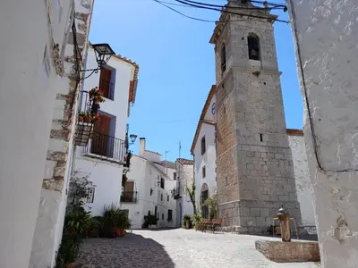 an alley with a tower in the middle of a building at L'Amagatall in Ahín