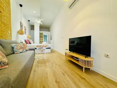 a living room with a couch and a flat screen tv at Dorado Cabanyal - Luxury Beachside Charm in Valencia