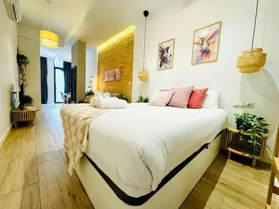 a bedroom with a large white bed with pink pillows at Dorado Cabanyal - Luxury Beachside Charm in Valencia