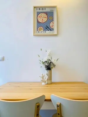 a wooden table with two chairs and a vase of flowers at Lindo Cabanyal - Comfort Family Beachside Apartment in Valencia