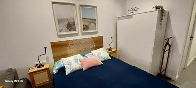 a bedroom with a blue bed and two windows at Lindo Cabanyal - Comfort Family Beachside Apartment in Valencia