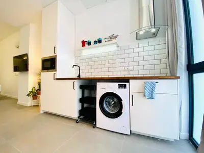 a washer and dryer in a room with a kitchen at Lindo Cabanyal - Comfort Family Beachside Apartment in Valencia