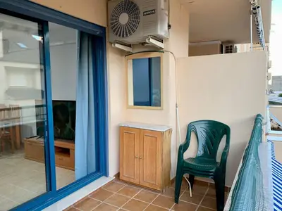 a green chair in a room with a window at Experience Valencia Bnb - Rincon del Mar - Apartamento Maravilloso a Canet Playa 100 mt in Canet de Berenguer