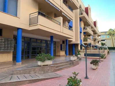 a building with blue columns and plants on a sidewalk at Experience Valencia Bnb - Rincon del Mar - Apartamento Maravilloso a Canet Playa 100 mt in Canet de Berenguer