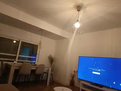 a living room with a tv and a table with chairs at vip rooms patraix in Valencia