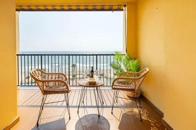 a balcony with a table and chairs and a large window at Travel Habitat Port Saplaya con vistas al Mar in Port Saplaya