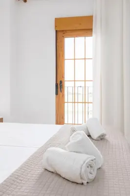 a bedroom with white towels on a bed at Travel Habitat Port Saplaya con vistas al Mar in Port Saplaya