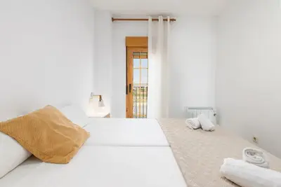 a white bedroom with two towels on a bed at Travel Habitat Port Saplaya con vistas al Mar in Port Saplaya