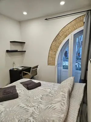 a bedroom with a bed and a desk and a window at Habitación céntrica de Lujo Gv 1 in Valencia