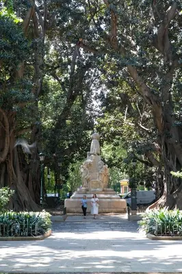 two people walking in front of a statue in a park at Habitación céntrica de Lujo Gv 5 in Valencia