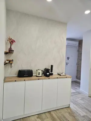 a kitchen with white cabinets and a wall at Habitación céntrica de Lujo Gv 2 in Valencia