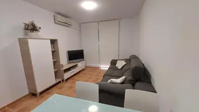 a living room with a couch and a television at Ático dúplex con vistas in Canet de Berenguer