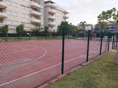 a tennis court with a net in front of a building at Ático dúplex con vistas in Canet de Berenguer