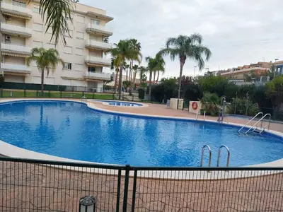 a large swimming pool in front of a building at Ático dúplex con vistas in Canet de Berenguer