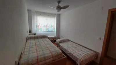 two beds in a room with a window at Ático dúplex con vistas in Canet de Berenguer