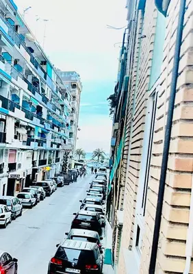 a row of cars parked on a street next to tall buildings at Piso Lorena Playa 1min walk in Puerto de Sagunto