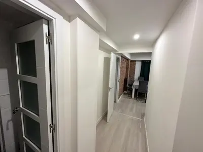 a hallway with white walls and an open door at Piso Lorena Playa 1min walk in Puerto de Sagunto