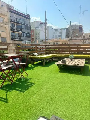 a patio with green grass and tables and benches at Valencia Bella Flats in Valencia