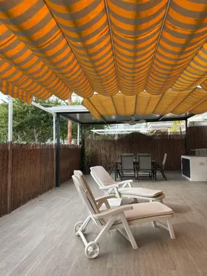 a group of lounge chairs under a large umbrella at APARTAMENTO PLANTA BAJA CANET DE BERENGUER in Canet de Berenguer