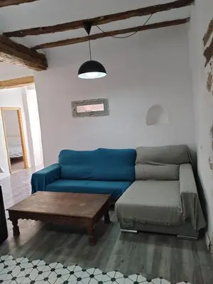 a living room with a blue couch and a coffee table at kats chulilla in Chulilla