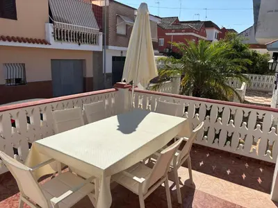 a white table and chairs on a balcony with an umbrella at Casa mediterránea junto al mar. in Chilches