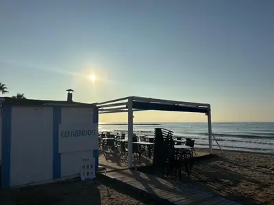 a shelter on the beach with a table and chairs at Casa mediterránea junto al mar. in Chilches