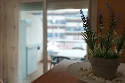 a vase with purple flowers sitting on a table at Acogedor apartamento en la playa de Canet in Canet de Berenguer