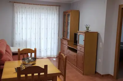 a living room with a table and a tv at Acogedor apartamento en la playa de Canet in Canet de Berenguer