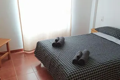 a bedroom with a bed with two gray objects on it at Acogedor apartamento en la playa de Canet in Canet de Berenguer