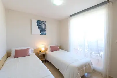 two beds in a room with a window at Enorme terraza con vistas al mar by Hometels in Puerto de Sagunto