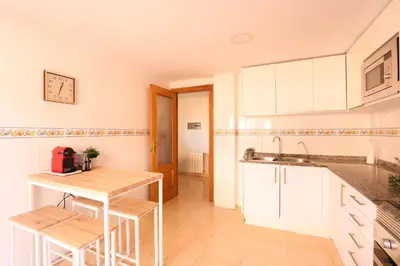 a kitchen with white cabinets and a counter top at Enorme terraza con vistas al mar by Hometels in Puerto de Sagunto