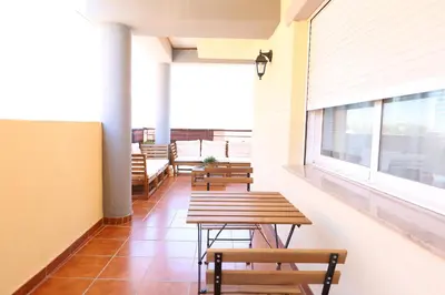 a row of tables and benches in a cafeteria at Enorme terraza con vistas al mar by Hometels in Puerto de Sagunto