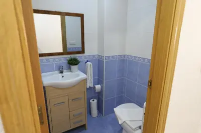 a bathroom with a sink and a toilet and a mirror at Enorme terraza con vistas al mar by Hometels in Puerto de Sagunto